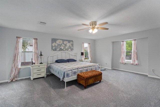4932 Woodstock Dr, Georgetown, TX 78633 - bedroom featuring multiple windows, dark colored carpet, baseboards, and a ceiling fan