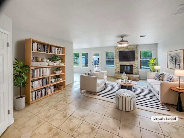 804 Dewberry Dr, Cedar Park, TX 78613 - living area featuring healthy amount of natural light, a stone fireplace, and light tile patterned flooring