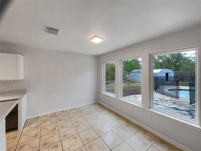 interior space with visible vents, baseboards, and light tile patterned flooring