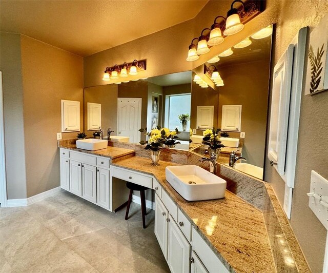 30105 Meadow Greens Dr, Georgetown, TX 78628 - bathroom featuring double vanity and a textured wall