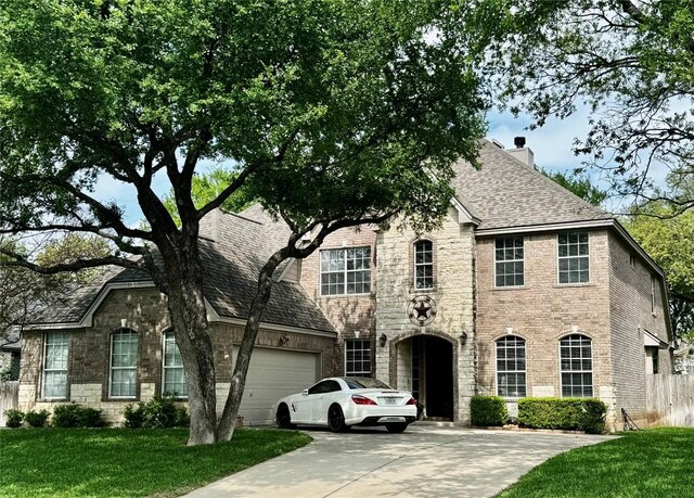 30105 Meadow Greens Dr, Georgetown, TX 78628 - view of front of house featuring an attached garage, a chimney, stone siding, driveway, and brick siding