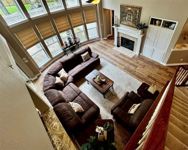 30105 Meadow Greens Dr, Georgetown, TX 78628 - living area featuring plenty of natural light, a tile fireplace, wood finished floors, stairs, and a high ceiling