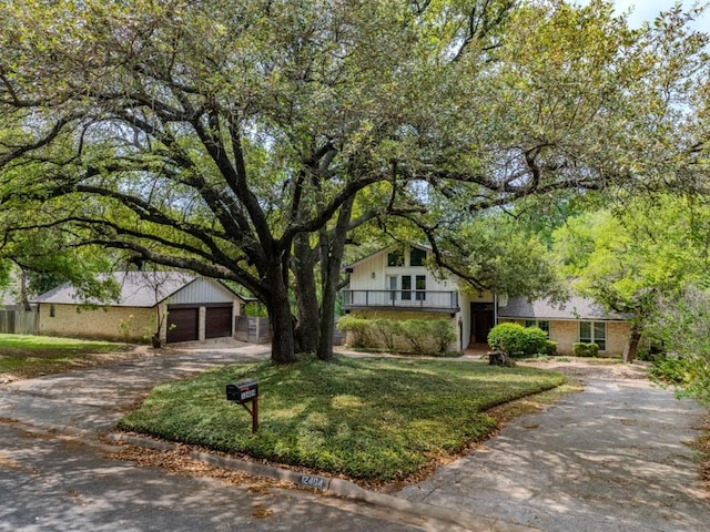 view of front of home with a front yard, concrete driveway, and a garage