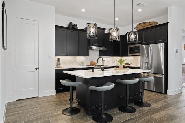 523 Jane Long, San Marcos, TX 78666 - kitchen with stainless steel appliances, wood finished floors, light countertops, dark cabinets, and recessed lighting