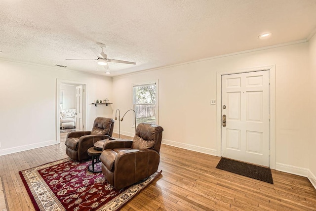 811 E 45th St, Austin, TX 78751 - living area featuring hardwood / wood-style floors, ceiling fan, a textured ceiling, baseboards, and ornamental molding