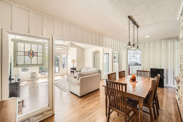 811 E 45th St, Austin, TX 78751 - dining area featuring healthy amount of natural light, light wood-style flooring, a decorative wall, and a textured ceiling
