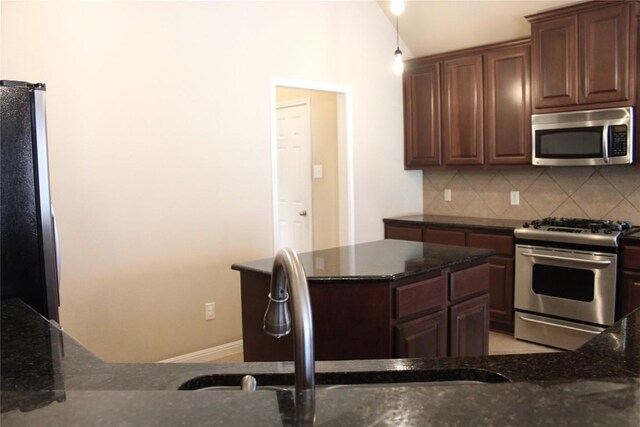 2718 Sun Mountain Dr, Leander, TX 78641 - kitchen with appliances with stainless steel finishes, tasteful backsplash, and dark stone countertops