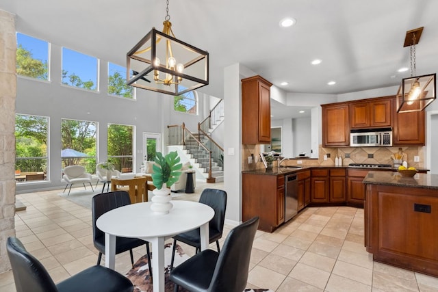 10408 Medinah Greens Dr, Austin, TX 78717 - kitchen featuring stainless steel appliances, brown cabinets, light tile patterned floors, decorative backsplash, and recessed lighting