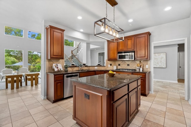 10408 Medinah Greens Dr, Austin, TX 78717 - kitchen with stainless steel appliances, a sink, a center island, tasteful backsplash, and hanging light fixtures