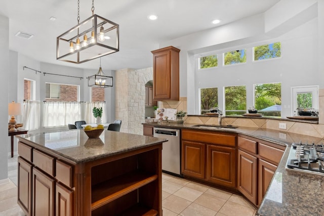 10408 Medinah Greens Dr, Austin, TX 78717 - kitchen featuring stainless steel appliances, a chandelier, a sink, brown cabinetry, and tasteful backsplash
