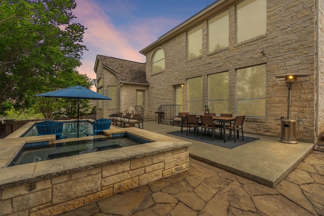 10408 Medinah Greens Dr, Austin, TX 78717 - patio terrace at dusk featuring a patio, outdoor dining area, and a pool with connected hot tub