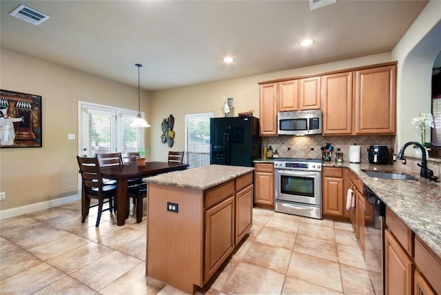 2433 Independence Dr Unit B105, Austin, TX 78745 - kitchen with a sink, visible vents, stainless steel appliances, a center island, and backsplash