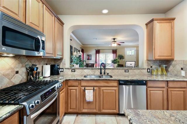 2433 Independence Dr Unit B105, Austin, TX 78745 - kitchen with light stone counters, a sink, stainless steel appliances, and arched walkways