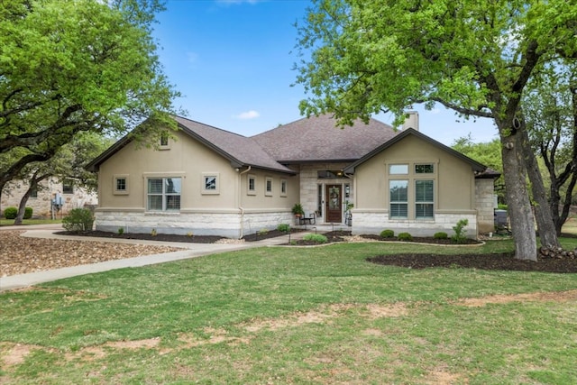 909 Highland Spring Ln, Georgetown, TX 78633 - view of front of house featuring stone siding, stucco siding, a front yard, and a chimney