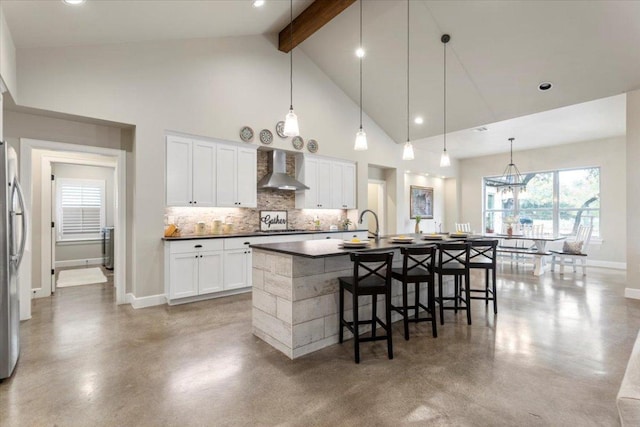 909 Highland Spring Ln, Georgetown, TX 78633 - kitchen featuring wall chimney range hood, beamed ceiling, freestanding refrigerator, tasteful backsplash, and concrete floors