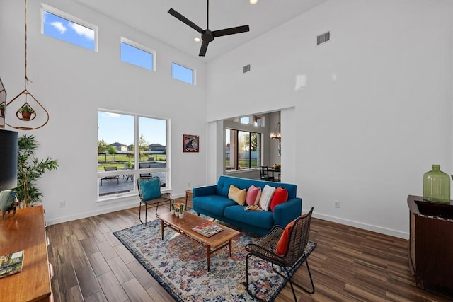 living area featuring baseboards, visible vents, a ceiling fan, and wood finished floors