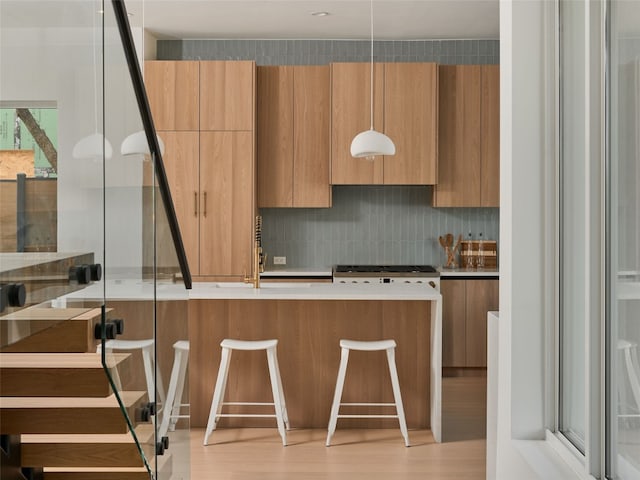 411 Krebs, Austin, TX 78704 - kitchen with modern cabinets, a breakfast bar, backsplash, light wood-style floors, and light countertops