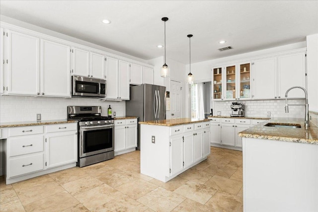 1019 Lone Buck Pass, Cedar Park, TX 78613 - kitchen with appliances with stainless steel finishes, backsplash, white cabinetry, a center island, and recessed lighting