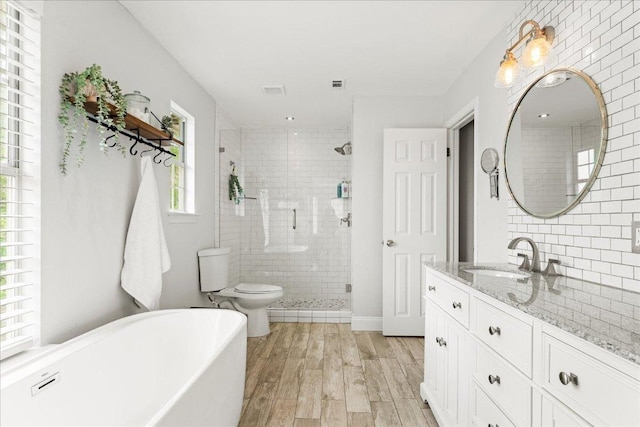 1019 Lone Buck Pass, Cedar Park, TX 78613 - bathroom featuring wood finished floors, a stall shower, a freestanding bath, and vanity