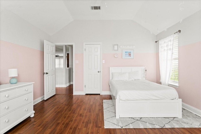 bedroom featuring visible vents, baseboards, wood finished floors, and vaulted ceiling