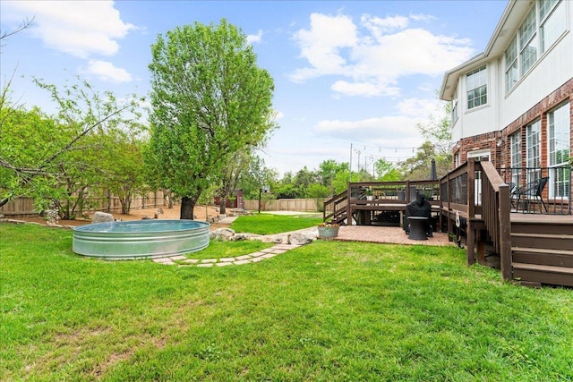 view of yard with a fenced backyard, a pool, stairs, and a deck