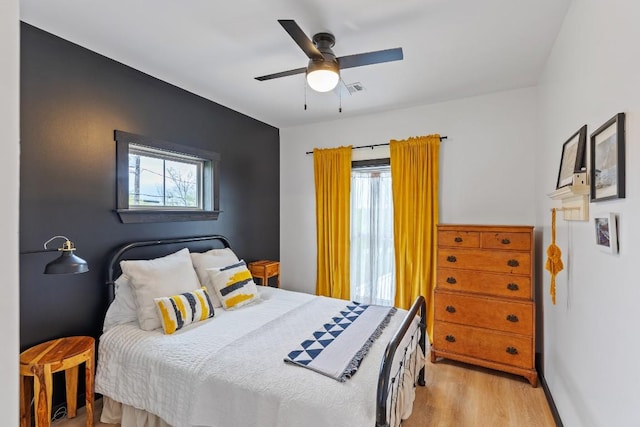 6810 River Oaks Dr, Kingsland, TX 78639 - bedroom with multiple windows, wood finished floors, and ceiling fan