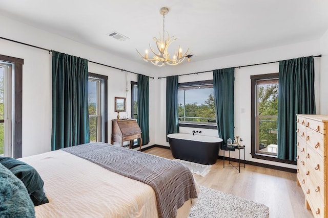 6810 River Oaks Dr, Kingsland, TX 78639 - bedroom with a chandelier and light wood-style floors