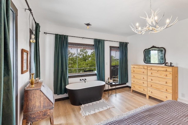 6810 River Oaks Dr, Kingsland, TX 78639 - bedroom with light wood-style flooring and a chandelier