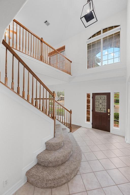 12452 Fairfax Ridge Pl, Austin, TX 78738 - foyer with a towering ceiling, stairs, tile patterned flooring, and baseboards