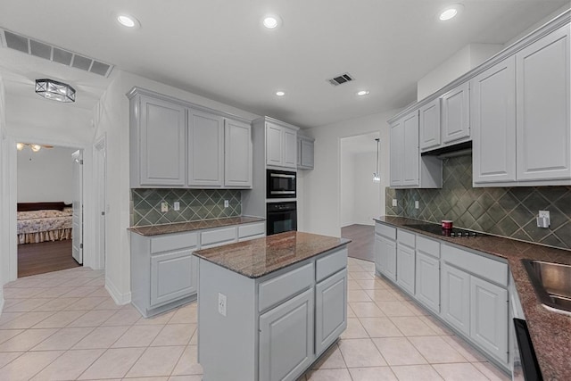 12452 Fairfax Ridge Pl, Austin, TX 78738 - kitchen featuring black appliances, light tile patterned floors, recessed lighting, gray cabinets, and backsplash