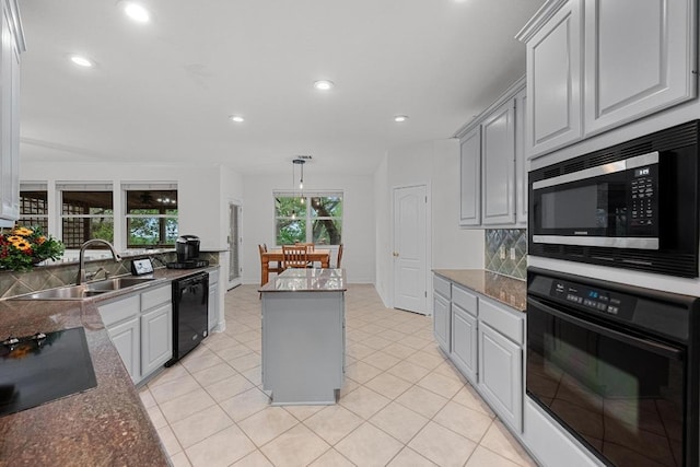 12452 Fairfax Ridge Pl, Austin, TX 78738 - kitchen featuring black appliances, a sink, backsplash, gray cabinets, and a kitchen island
