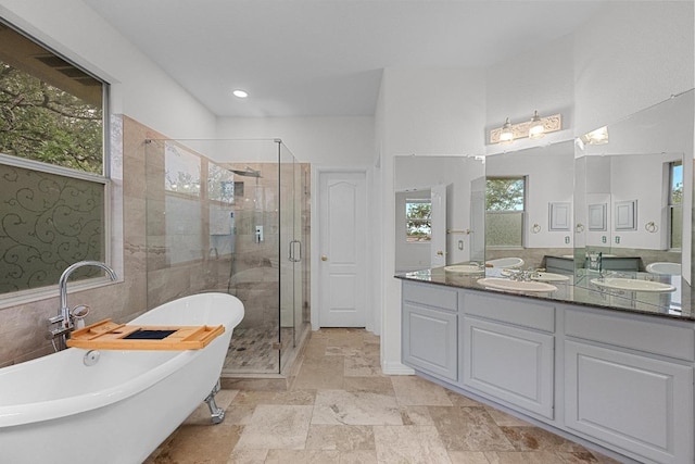 12452 Fairfax Ridge Pl, Austin, TX 78738 - bathroom with a stall shower, a freestanding bath, double vanity, stone finish floors, and recessed lighting