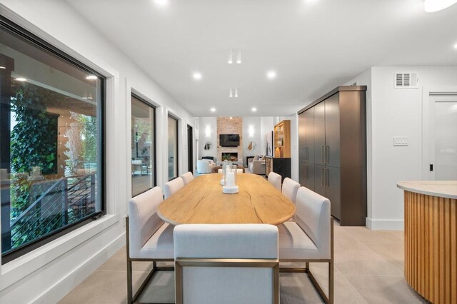 dining area featuring recessed lighting, visible vents, a large fireplace, and light tile patterned floors
