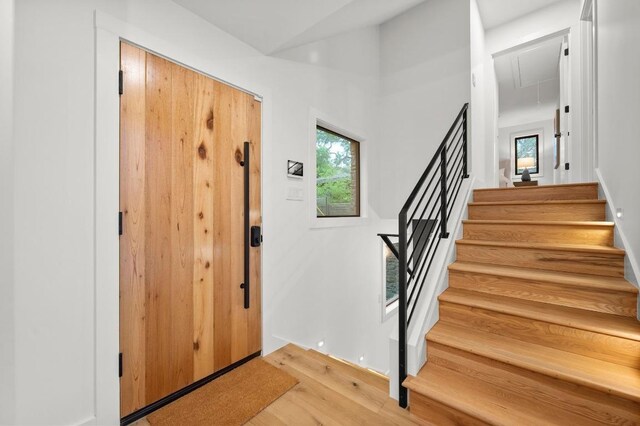 foyer entrance featuring a healthy amount of sunlight, stairs, and light wood-style flooring
