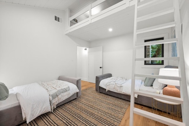 bedroom featuring lofted ceiling, wood finished floors, visible vents, and recessed lighting