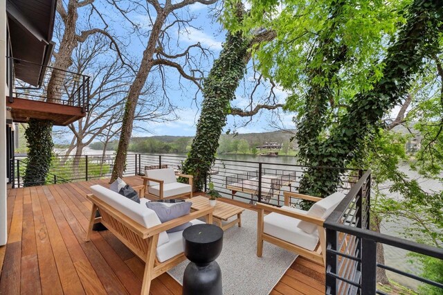 wooden deck with a water view and an outdoor hangout area