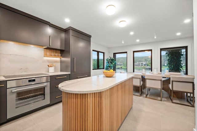 kitchen with black electric cooktop, oven, and modern cabinets