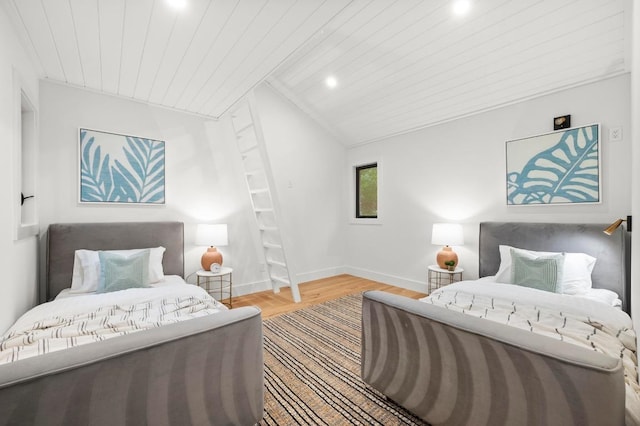 bedroom with vaulted ceiling, baseboards, wood ceiling, and wood finished floors