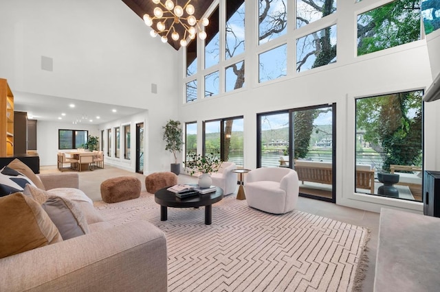 living area featuring recessed lighting, a towering ceiling, and an inviting chandelier
