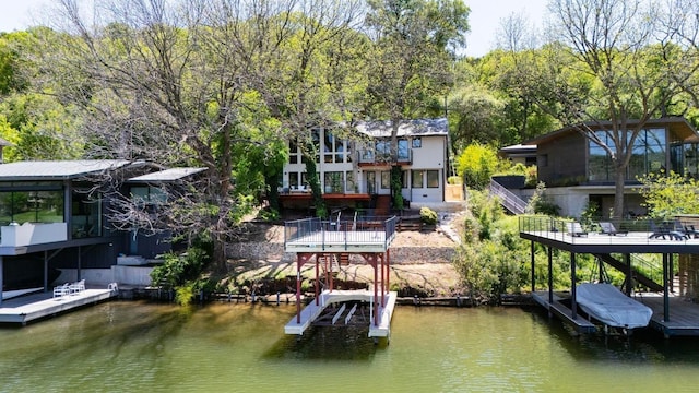 dock area with stairs, a water view, and boat lift