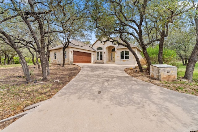 518 Coventry Rd, Spicewood, TX 78669 - view of front of property featuring an attached garage, driveway, and stone siding