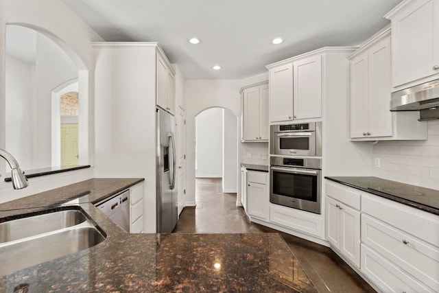 518 Coventry Rd, Spicewood, TX 78669 - kitchen featuring a sink, appliances with stainless steel finishes, arched walkways, recessed lighting, and decorative backsplash