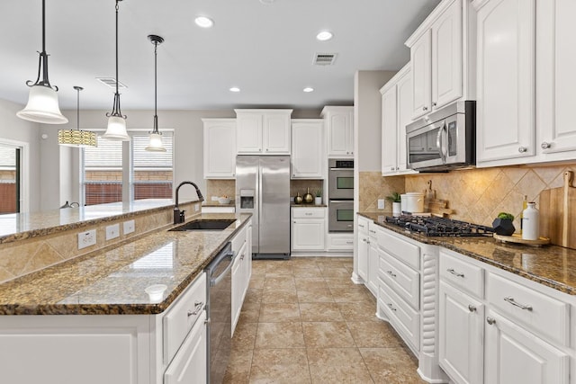 3312 Cortes Pl, Round Rock, TX 78665 - kitchen with appliances with stainless steel finishes, white cabinetry, decorative backsplash, dark stone countertops, and recessed lighting