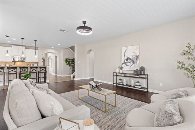 3312 Cortes Pl, Round Rock, TX 78665 - living room with arched walkways, dark wood-style floors, and recessed lighting