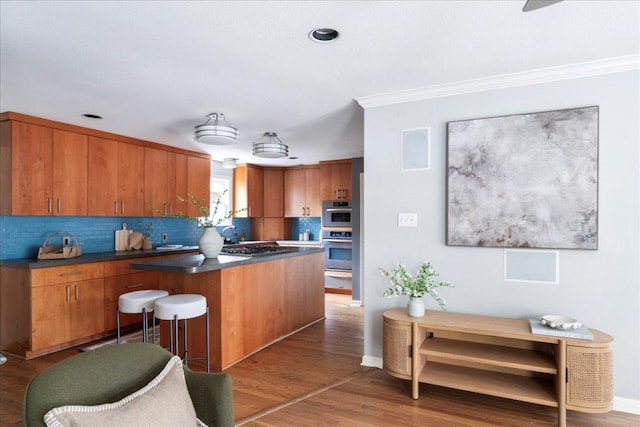 2210 Meadowbrook Dr, Austin, TX 78703 - kitchen with stainless steel appliances, backsplash, dark countertops, light wood finished floors, and brown cabinetry
