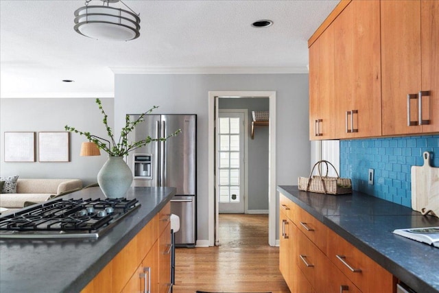 2210 Meadowbrook Dr, Austin, TX 78703 - kitchen with stainless steel appliances, dark countertops, light wood finished floors, and ornamental molding
