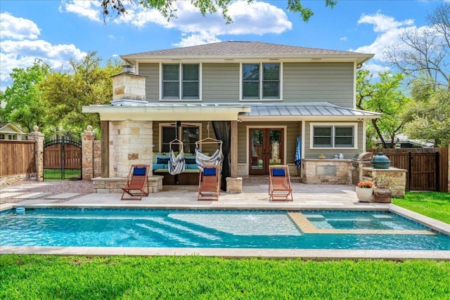 2210 Meadowbrook Dr, Austin, TX 78703 - rear view of property featuring area for grilling, french doors, a standing seam roof, a gate, and a patio