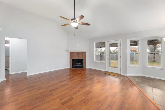 214 Crystal Knoll Blvd, Georgetown, TX 78626 - unfurnished living room featuring a ceiling fan, high vaulted ceiling, a tile fireplace, and wood finished floors