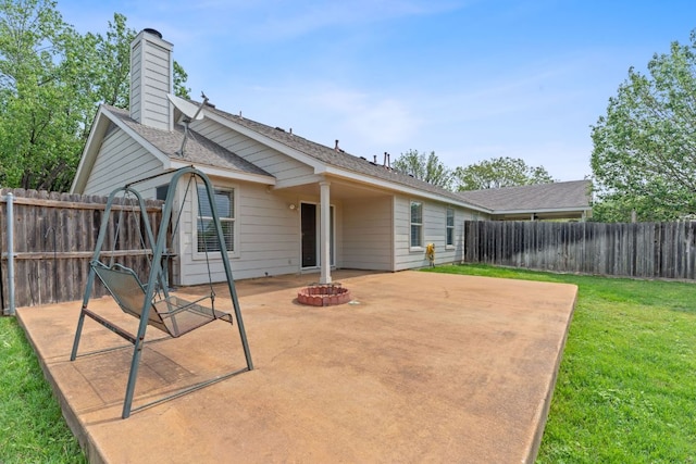 198 Prairie Springs Loop, Georgetown, TX 78626 - rear view of house with a chimney, a fenced backyard, a yard, a patio, and a fire pit