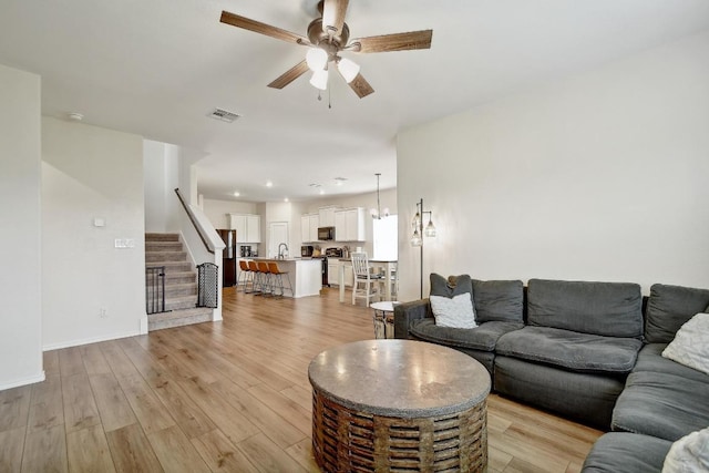 118 Esparza Dr, Bastrop, TX 78602 - living room featuring a ceiling fan, stairs, and light wood-style flooring